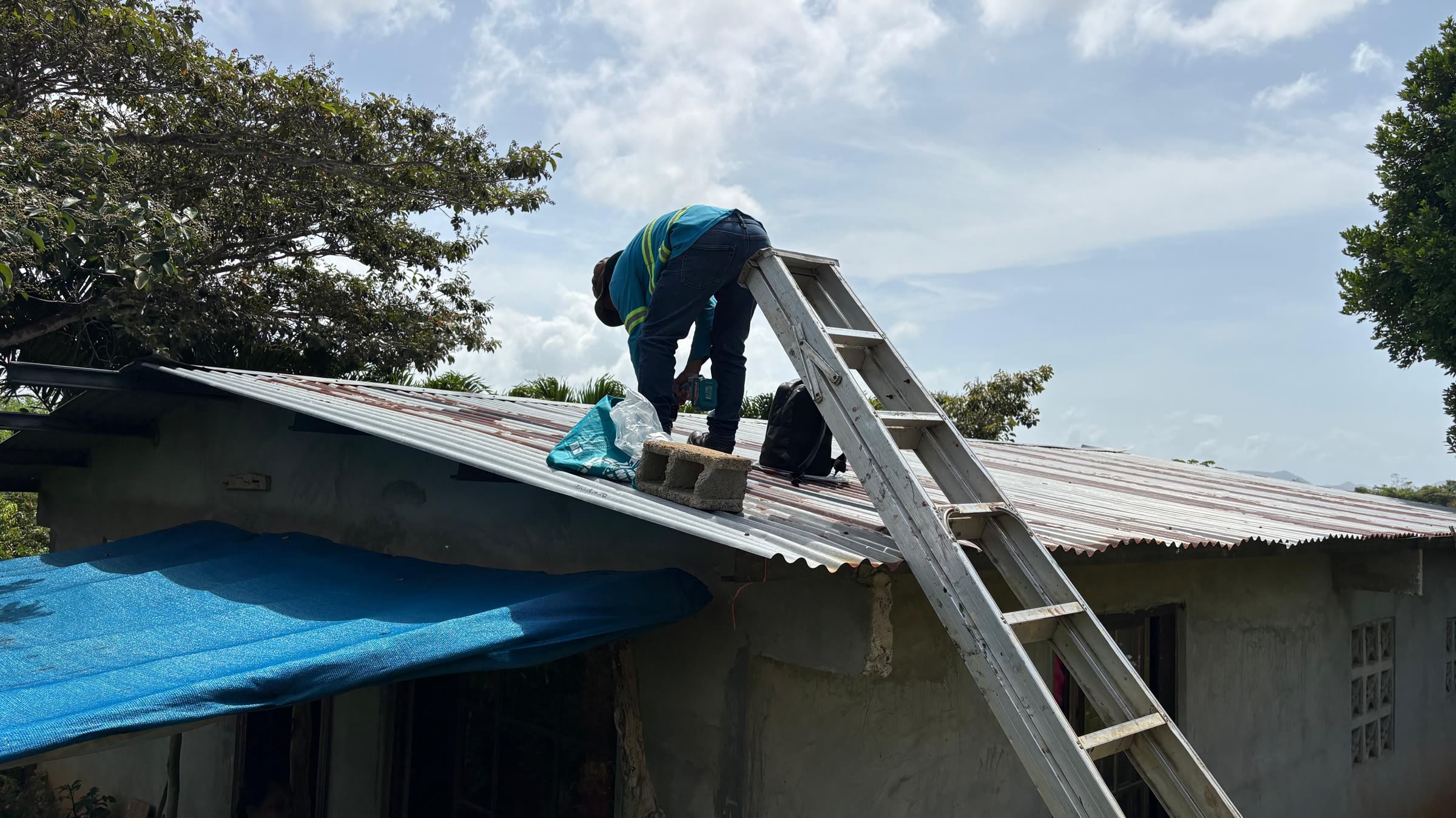 An installer on a roof fitting a solar panel.