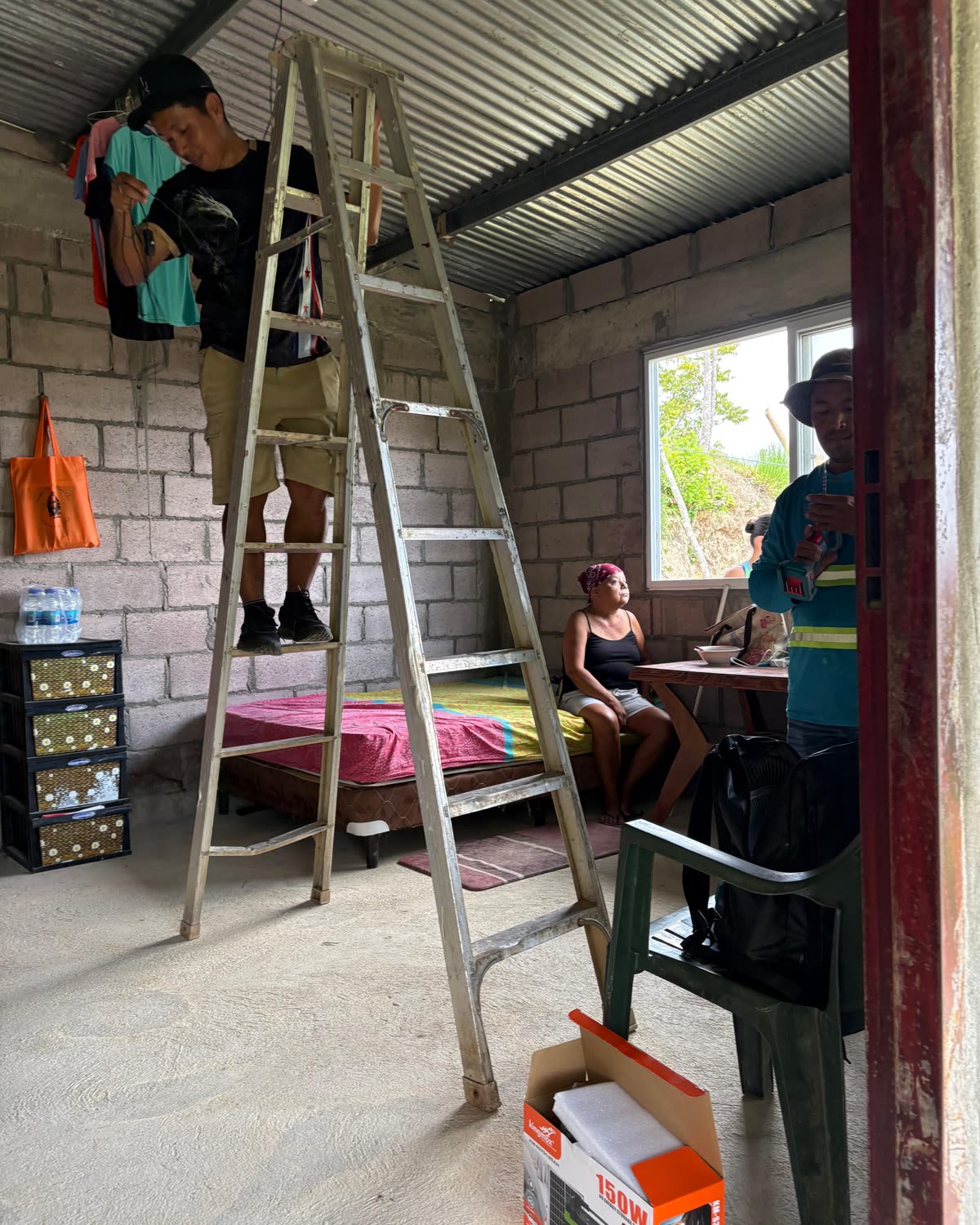 A family sitting inside their home while the wiring goes in.