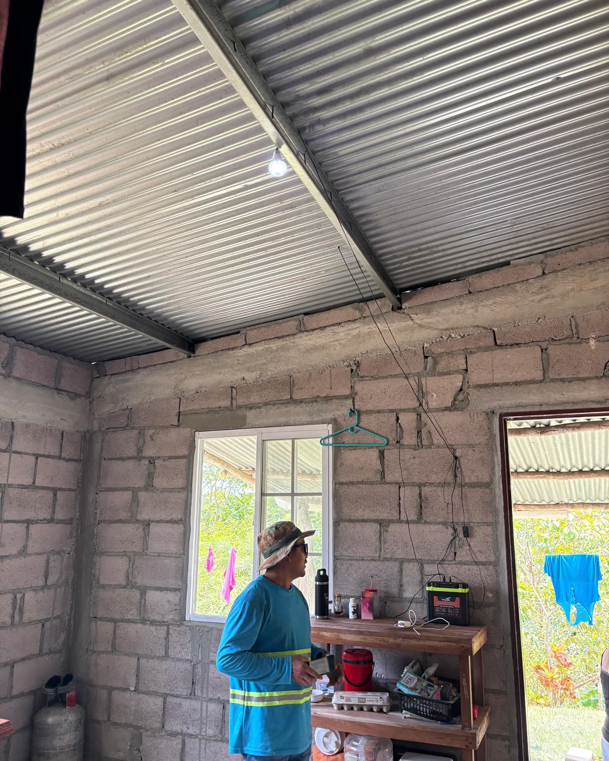A woman standing in her kitchen beside the window.