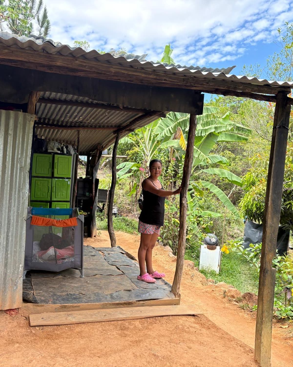 A woman standing on the porch of her home.